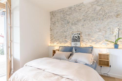 康博莱班Jondoni Laurendi Kanbo的一间卧室设有一张床和石墙