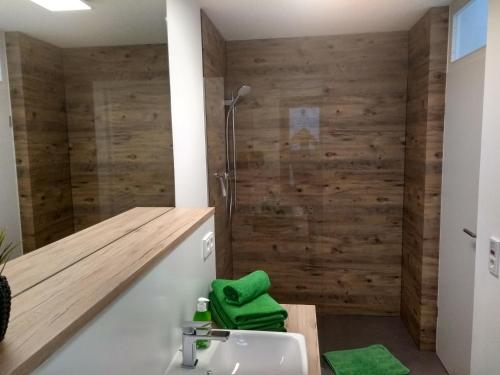 Winterstein塞姆巴赫塔尔公寓的浴室配有水槽和带木墙的淋浴
