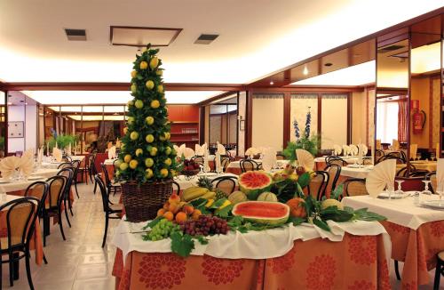 圣乔瓦尼·罗通多加贾诺酒店的餐桌上的饭厅,有圣诞树