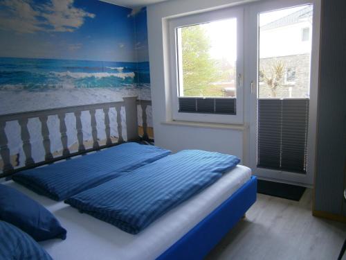 克伦胡森Haus Steinbach的一间卧室设有一张带窗户和蓝色墙壁的床。