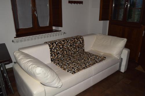 贝加德奥阿尔博拉达德尔奥酒店的一张白色的沙发,上面有豹子毯子