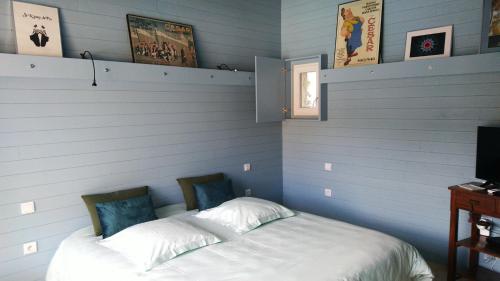 埃瑞兹Sous les chênes, en Provence的卧室配有白色床和蓝色的墙壁