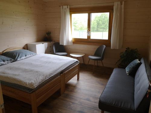 普热罗夫Resort Radslavice的一间卧室配有一张床、两把椅子和一个窗户