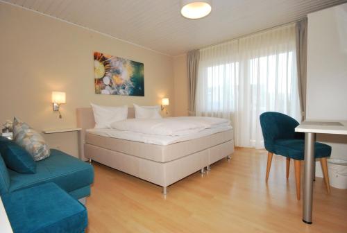 赖因伯伦斗兽场旅馆的酒店客房,配有床和蓝色的沙发