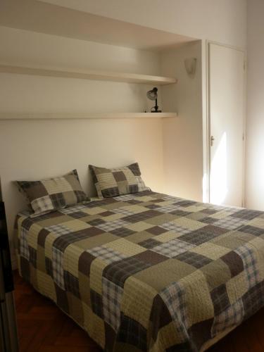 布宜诺斯艾利斯Excelente departamento en Retiro的一间卧室配有一张带 ⁇ 子毯子的床