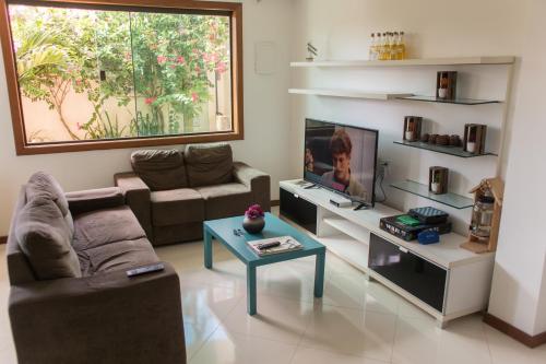 阿拉亚尔-杜卡布Enseada Hostel的带沙发和电视的客厅