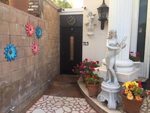 洛杉矶Entire Second Flr - Santa Monica Luxury Roman Villa的花朵在门前的雕像