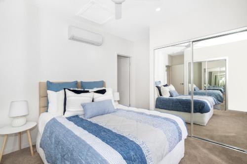 布里斯班Park Avenue Terrace House Sleeps 9的一间卧室配有两张床和镜子