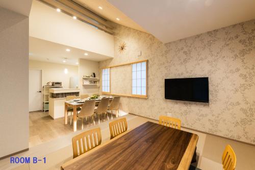 箱根Guest Villa Hakone Yumoto RiverSide的用餐室以及带桌子和电视的厨房。