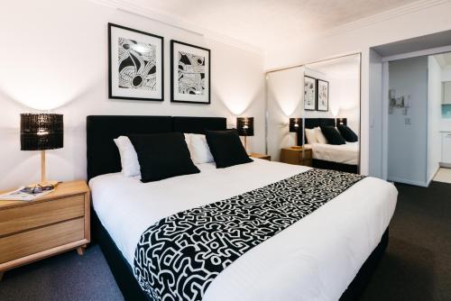 布里斯班Gabba Central Apartments的一间卧室配有一张大床,提供黑白毯子