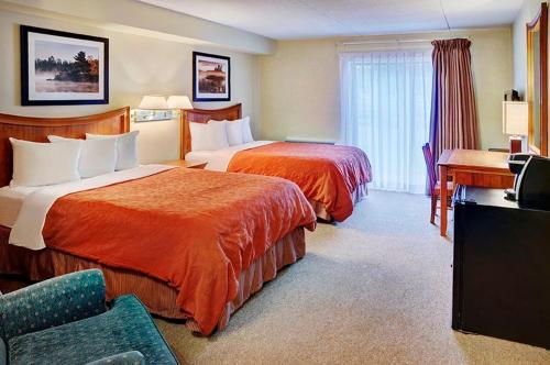 汤普森Thompson's Best Value Inn & Suites的酒店客房配有两张床和一张书桌