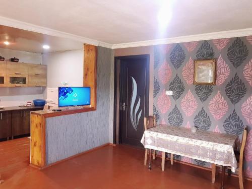 Udabnowine valley的一间设有桌子的用餐室和墙上的电视