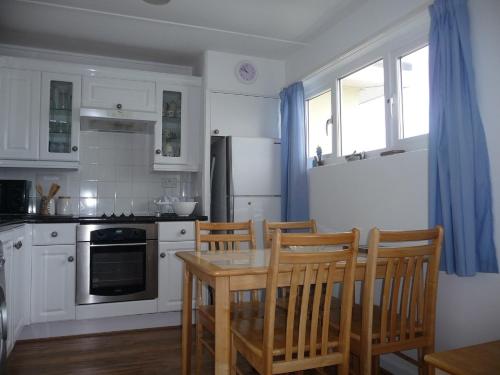 佩伦波斯151 Perran Sands的厨房配有桌椅和冰箱。