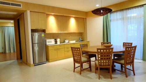 七岩Hua Hin Blue Lagoon的厨房配有桌椅和冰箱。