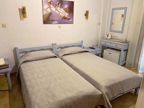 毕达哥利翁Sunshine Pension的一间卧室设有两张床,墙上挂着一幅画