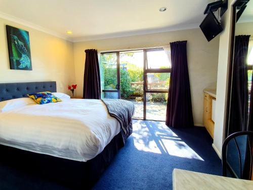 凯库拉Te Mahuru Retreat的一间卧室设有一张床和一个大窗户