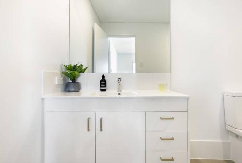 珀斯Minimalist Penthouse Condo with Skyline Vistas的白色的浴室设有水槽和镜子