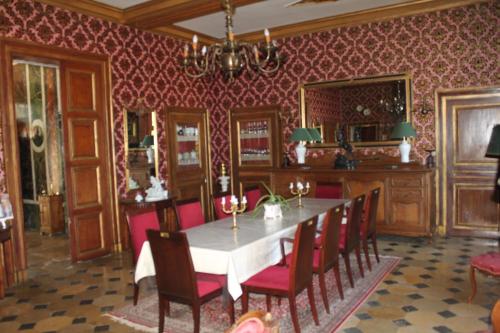 Deux-ChaisesChateau de Longeville的一间设有桌子和红色壁纸的用餐室