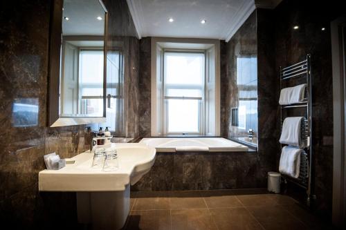 锡米尔Seamill Hydro Hotel的浴室配有盥洗盆和浴缸。