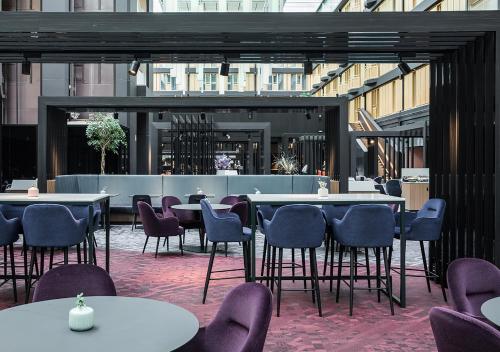 哥德堡哥德堡斯堪的纳维亚丽笙酒店的大楼内带桌椅的餐厅