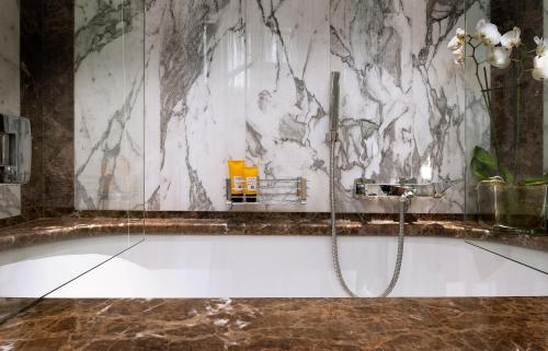 佛罗伦萨Be ONE - Ricci Collection的带浴缸的浴室和大理石墙