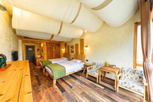 淳安千岛湖暖晚民宿的一间卧室配有两张床和一张桌子及椅子