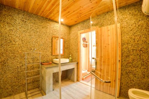 淳安千岛湖暖晚民宿的一间带玻璃淋浴和水槽的浴室