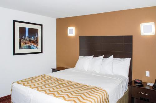 Manhasset曼哈塞特旅行山林小屋的酒店客房带一张大床,带白色床单