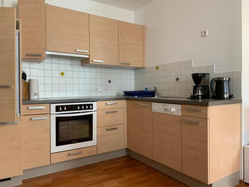 利恩茨Haus Helga的厨房配有木制橱柜和炉灶烤箱。