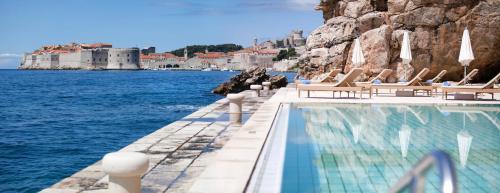 杜布罗夫尼克阿根廷豪华别墅酒店的一个带躺椅和水的游泳池