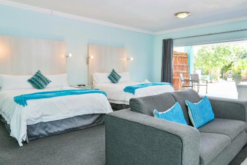 伊丽莎白港AL-BEIT LODGE的酒店客房,设有两张床和一张沙发