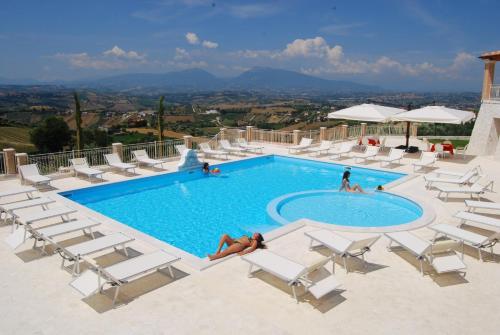 托尔托雷托因坎提度假酒店的一个带白色椅子的游泳池,一群人