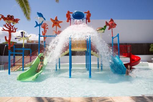 圣安东尼奥湾Coral Star Hotel的游泳池里的水滑梯,人们在玩耍