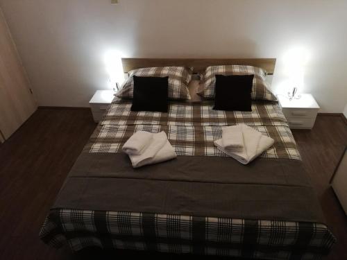SavarApartmani Zdenka Savar-Maslina的一间卧室配有一张带两个枕头和两张桌子的床。