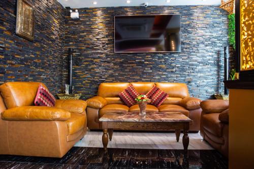 芭东海滩BAB ALHARA HOTEL的客厅配有真皮沙发和电视