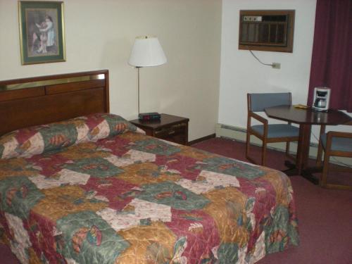 Waseca沃西卡美国汽车旅馆的酒店客房配有一张床铺和一张桌子。