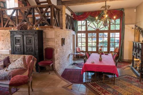 Corcelles-les-ArtsLa Cuverie du Château的客厅配有一张桌子和红色桌布