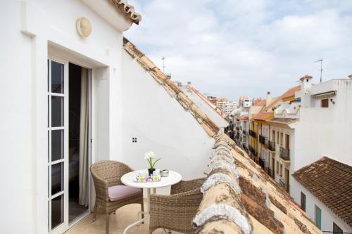 福恩吉罗拉Hotel Marbella的大楼内的阳台配有桌椅