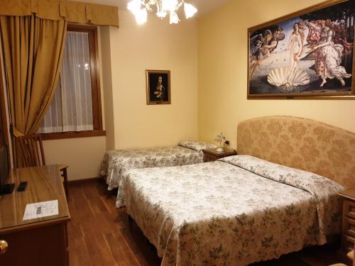 RontaHotel La Rosa的酒店客房设有两张床,墙上挂有绘画作品