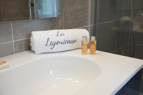 拉·寿塞·圣·威Château des Basses Roches的浴室水槽上方有2瓶水
