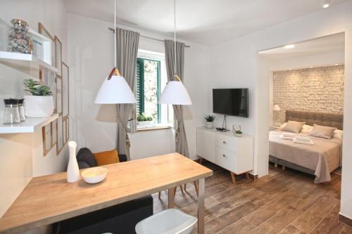 斯普利特Apartments Tessera的一个小客厅,配有一张床和一张桌子