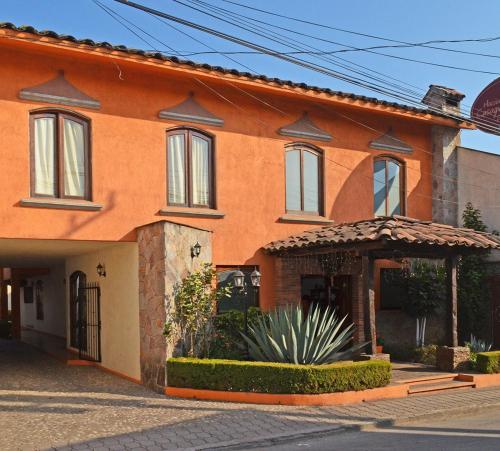 萨卡特兰Casa Grande的一座橙色房子,前面设有一个凉亭