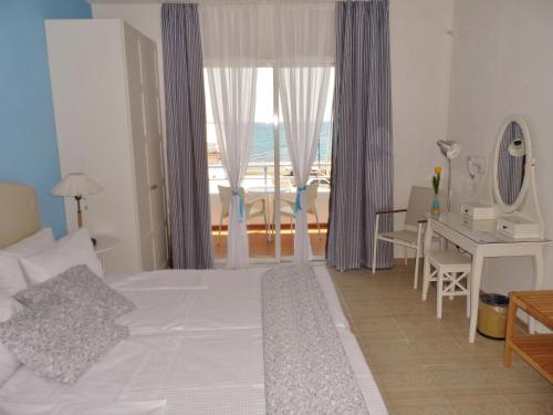希俄斯海滨一室公寓和公寓的一间卧室配有一张床、一张书桌和一个窗户。