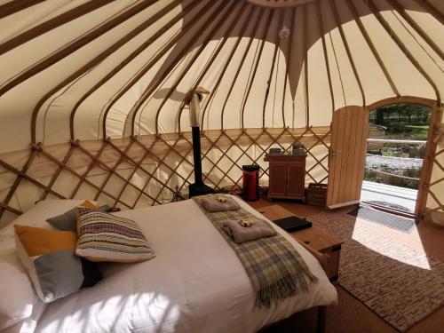 巴特米尔Syke Farm Campsite - Yurt's and Shepherds Hut的蒙古包内一间卧室,配有一张床
