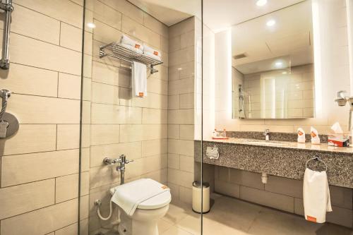 瑟古邦巴淡岛海滨哈里斯度假村的一间带卫生间、水槽和镜子的浴室