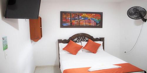 基布多Hotel el imperio的一间卧室配有带橙色枕头和绘画的床。