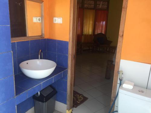 Weetebula奥罗海滩住宿加早餐旅馆的浴室设有蓝色瓷砖墙面上的碗水槽