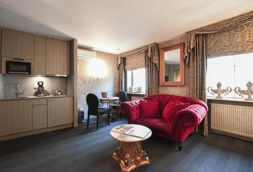克诺克－海斯特德劳里埃住宅酒店的客厅配有红色的沙发和桌子