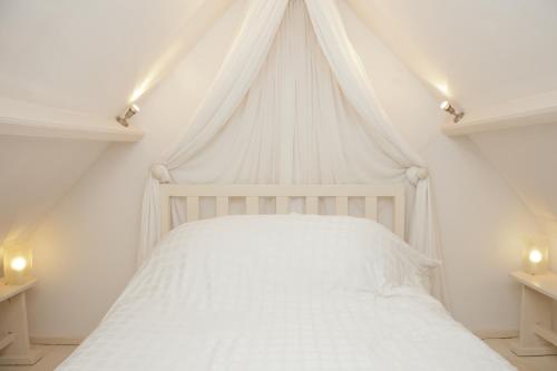 MathernWelsh Gatehouse的卧室内的白色床和天蓬