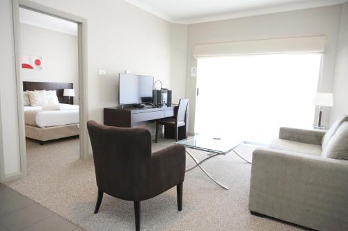 格里菲斯Centrepoint Apartments Griffith的客厅配有一张床和一张桌子及椅子